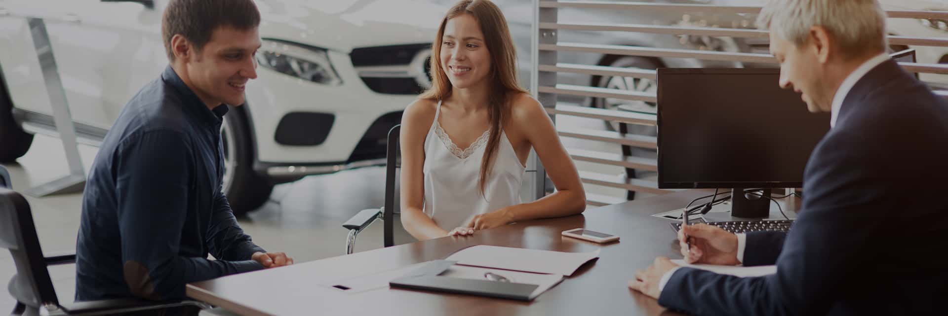 couple with finance papers at dealership