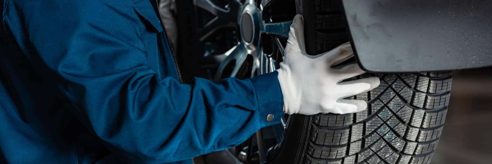 zoomed in shot of mechanic putting wheel back on. 
