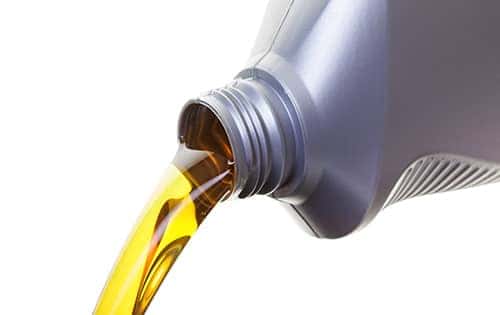 oil being poured out of plastic grey container