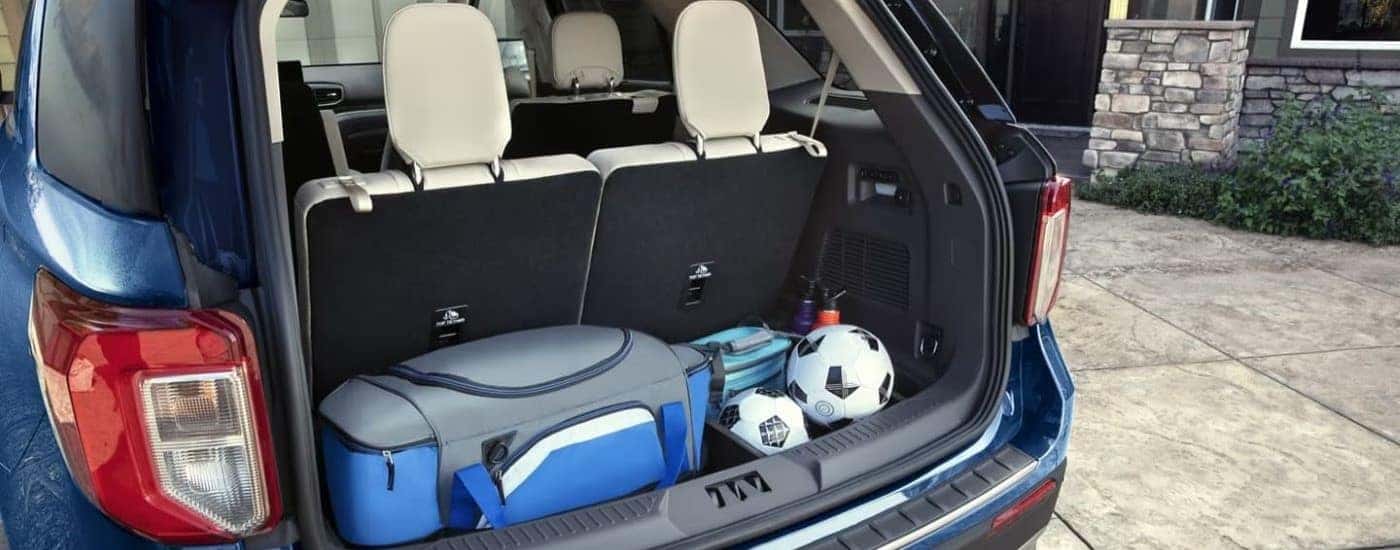 Gear is shown in the trunk of a blue 2021 Ford Explorer.