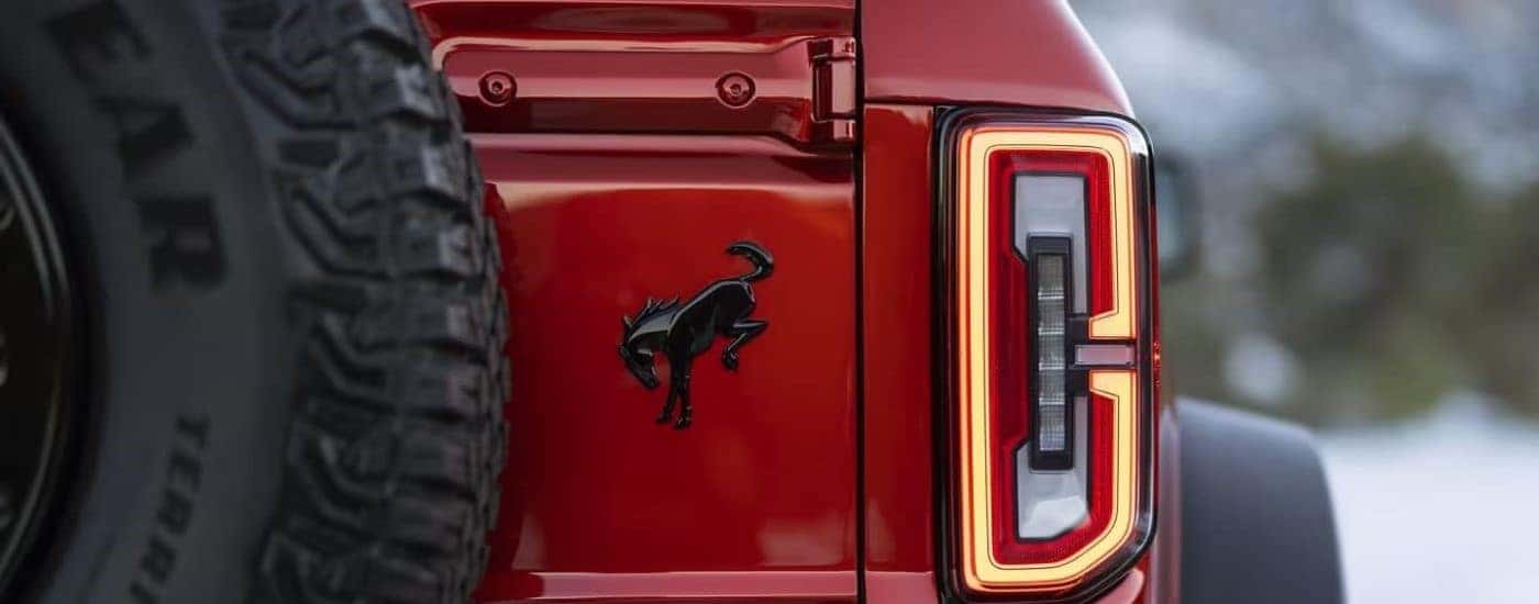 A close up shows the trunk badge on a red 2022 Ford Bronco Wildtrak.