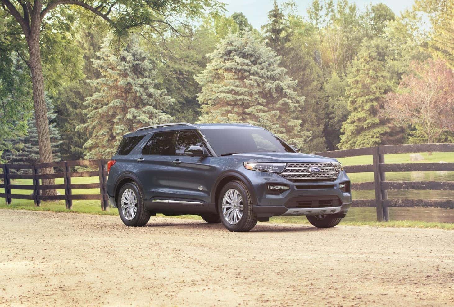 Ford Explorer parked by wooden fence among the trees