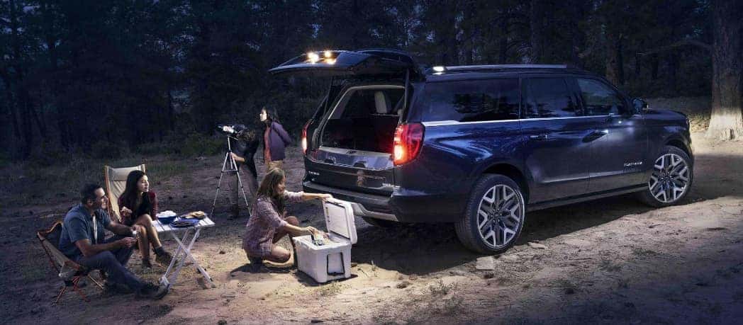 A group of friends sets up camping supplies outside their 2025 Expedition.