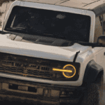 A white Ford Bronco kicking up dust as it drives off-road.