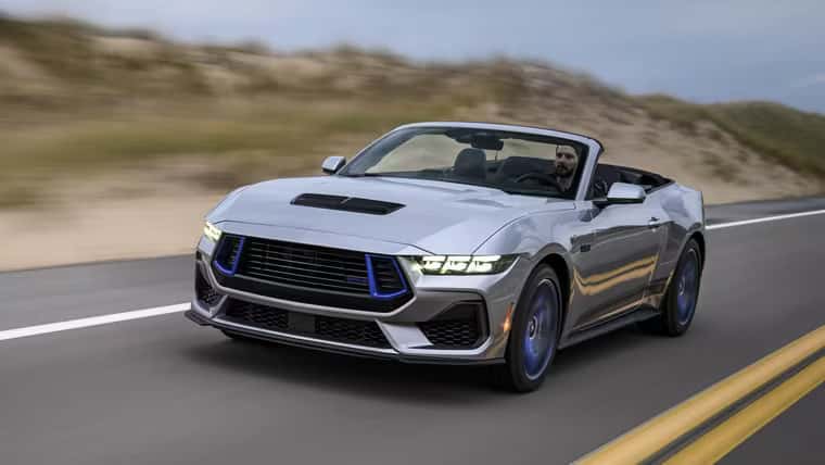 a silver ford mustang driving on the open highway