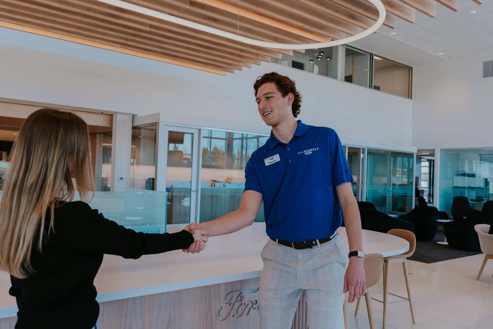 Shaking hands with a dealership sales representative for the purchase of a vehicle