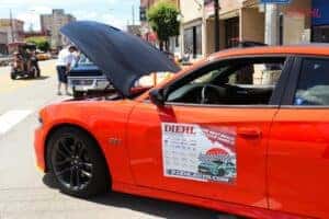 a side photo of a red dodge with the hood up