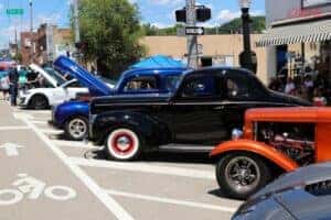 three vintage vehicles with the hood up