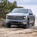 2024 Ford F-150 Lightning driving on a dirt road