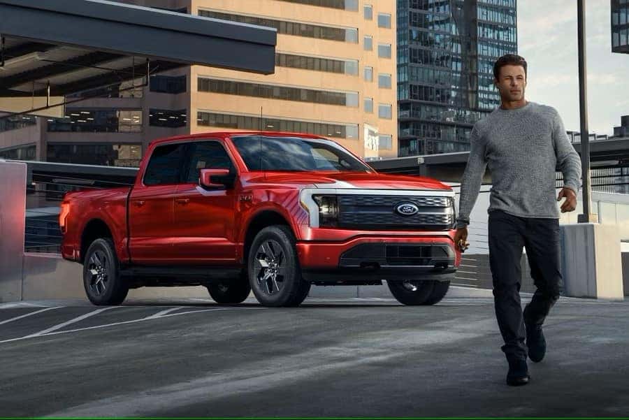 Exterior shot of man in front of house with a white Explorer® SUV cell phone in hand