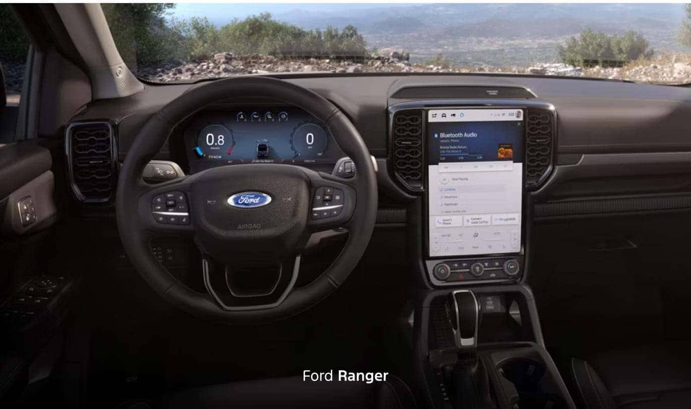 Ford Ranger interior featuring a multifunction steering wheel, digital instrument cluster and a large vertical center touchscreen.