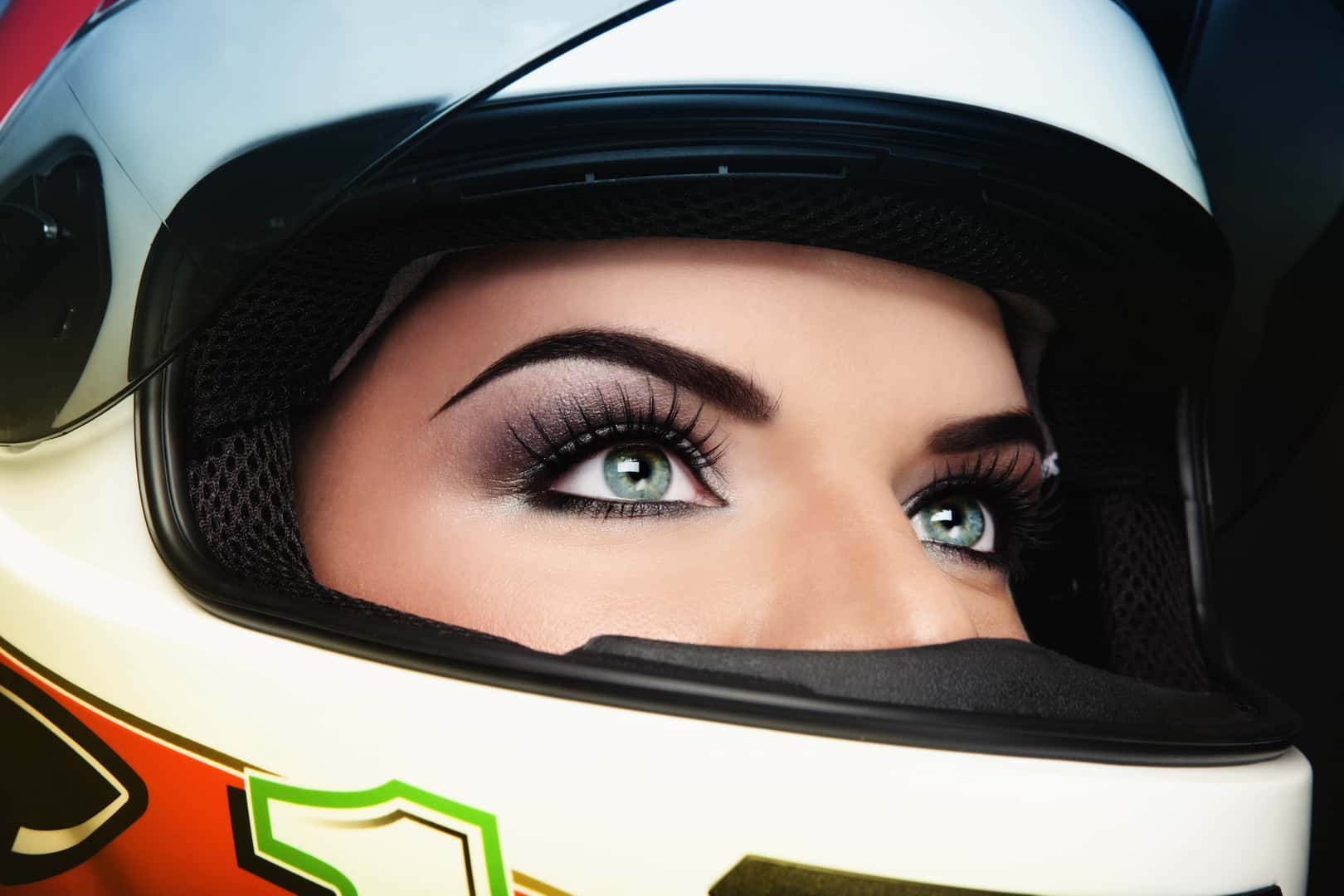 Close-up portrait of beautiful woman with stylish makeup in biker helmet