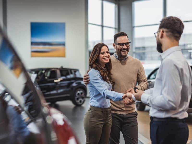 Couple shaking hands with sales person