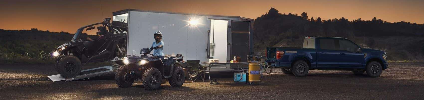 Ford F-150 parked in field with truck hitched containing atvs from Ford F-150 Lease 
