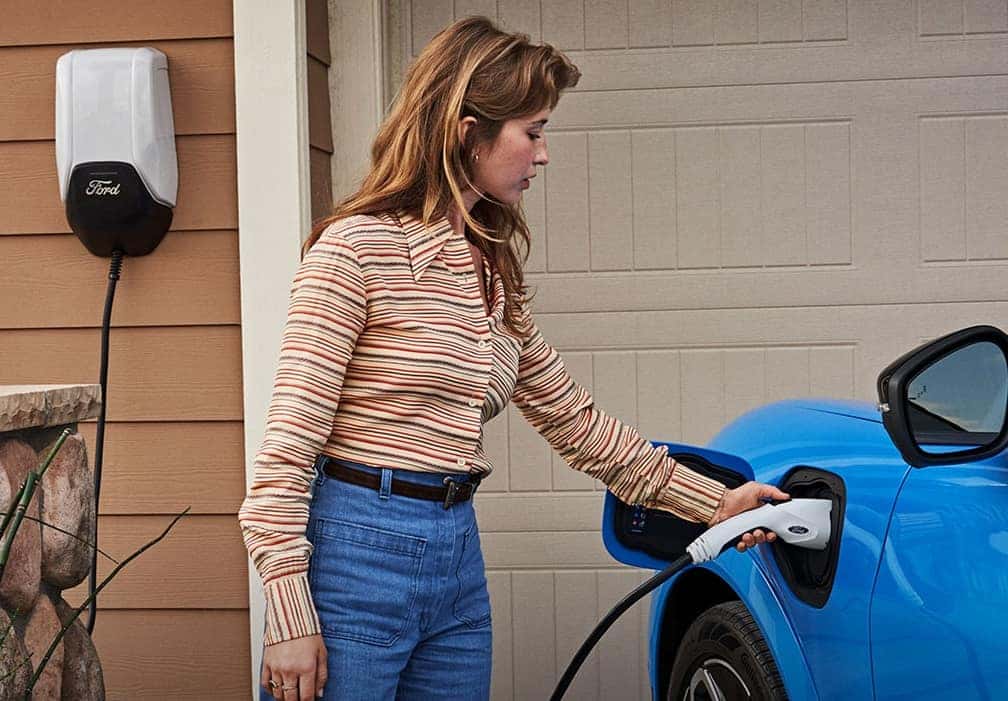 Woman charging her Ford Mustang Mach-E in her driveway