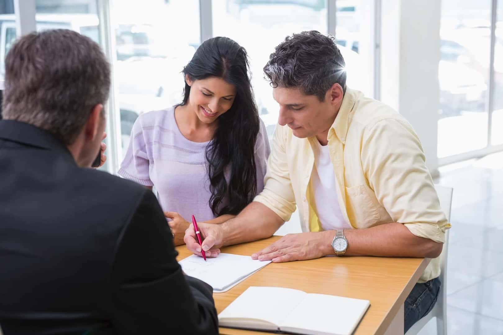 Couple signing paperwork at Ford Finanace Center in California for new Ford vehicle