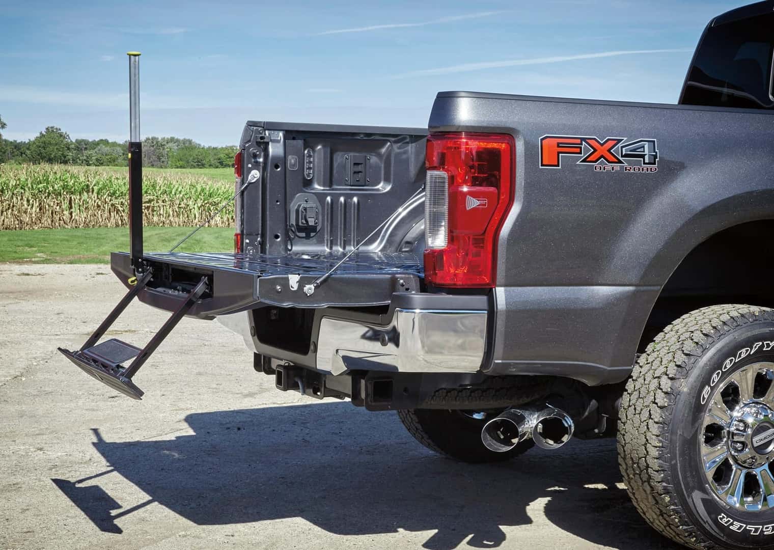 Ford Super Duty truck bed door open with step ladder pulled down for easy loading