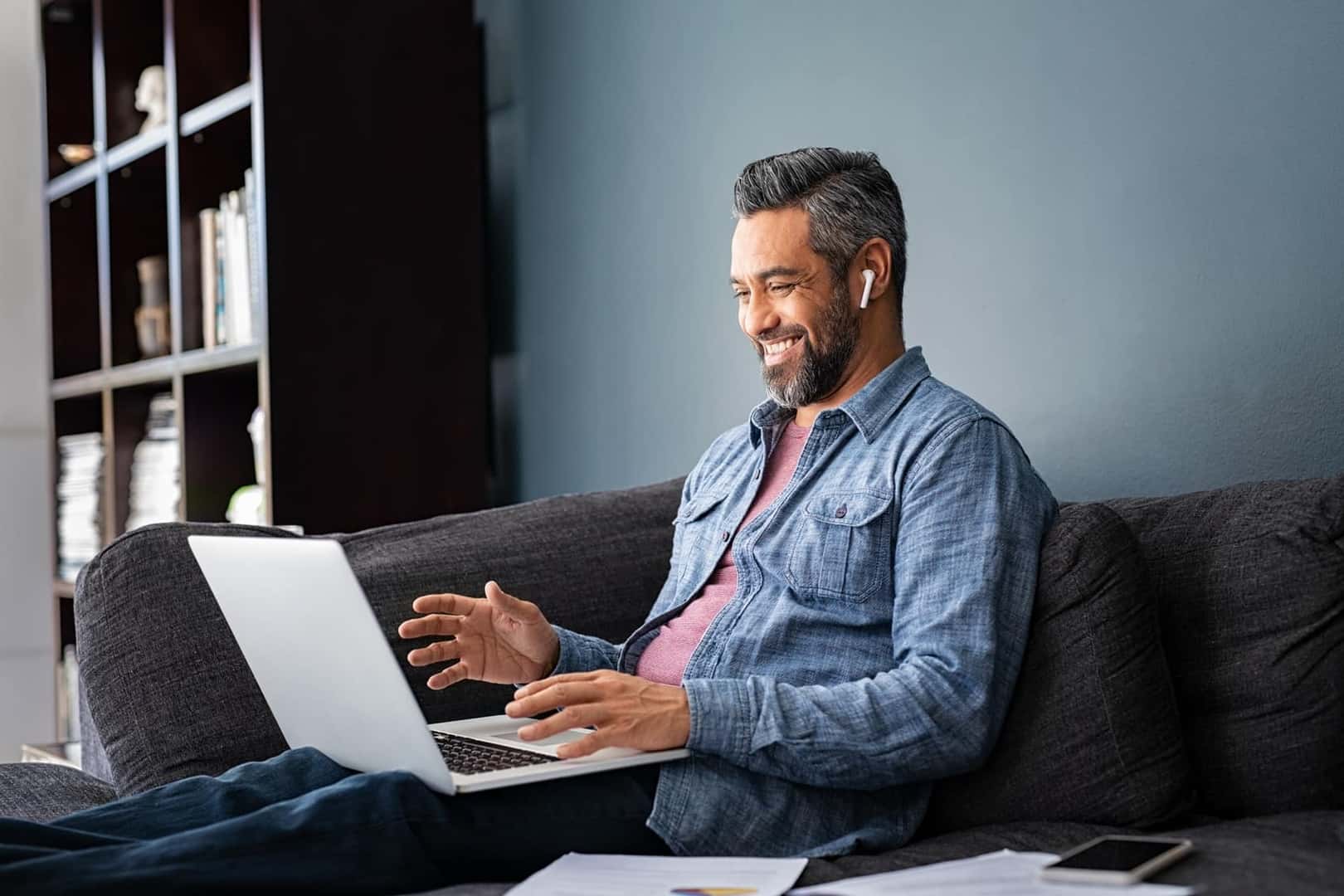 Man sitting on couch using his laptop to search online for Ford Accessories and Parts