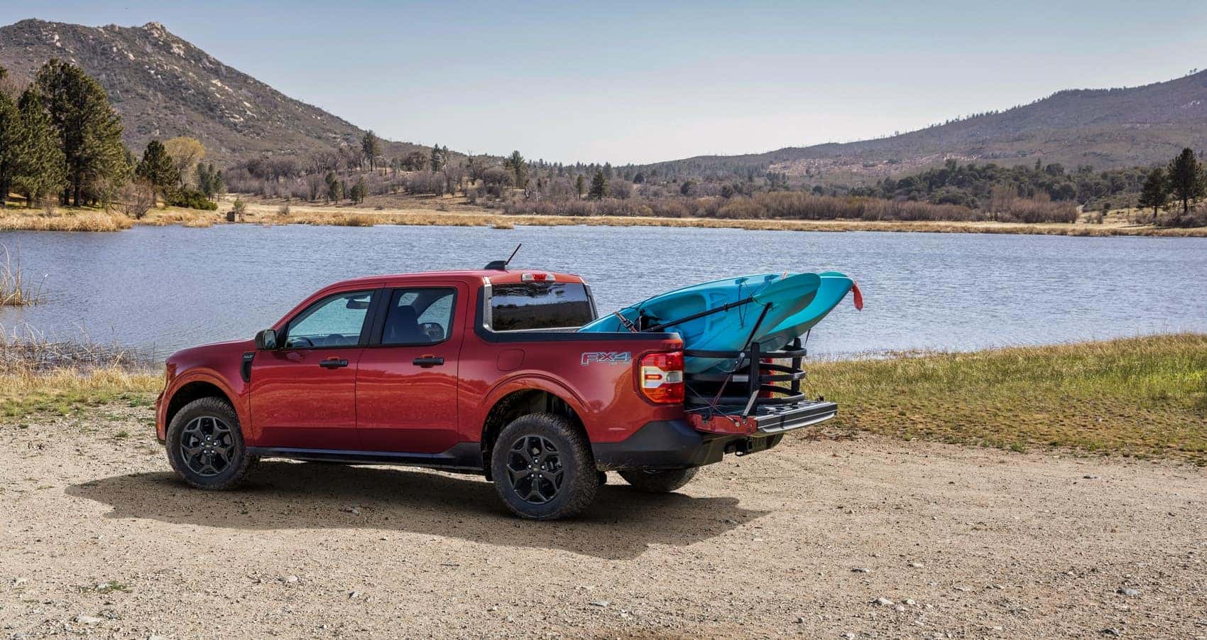 Ford Maverick parked at lake shore with canoe in truck bed from Ford Maverick Lease in Upland CA