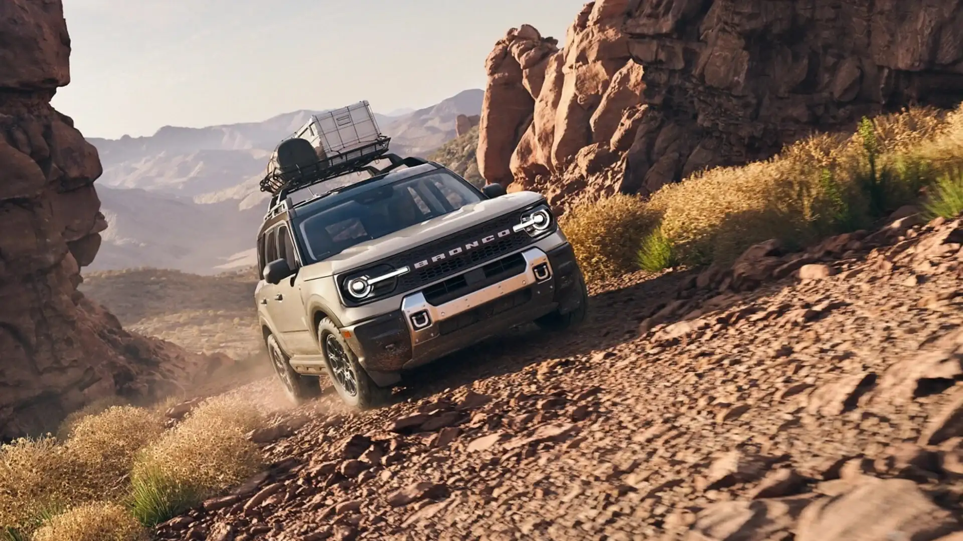 2025 Ford Bronco Sport descending rocky trail with cargo rack in desert terrain.