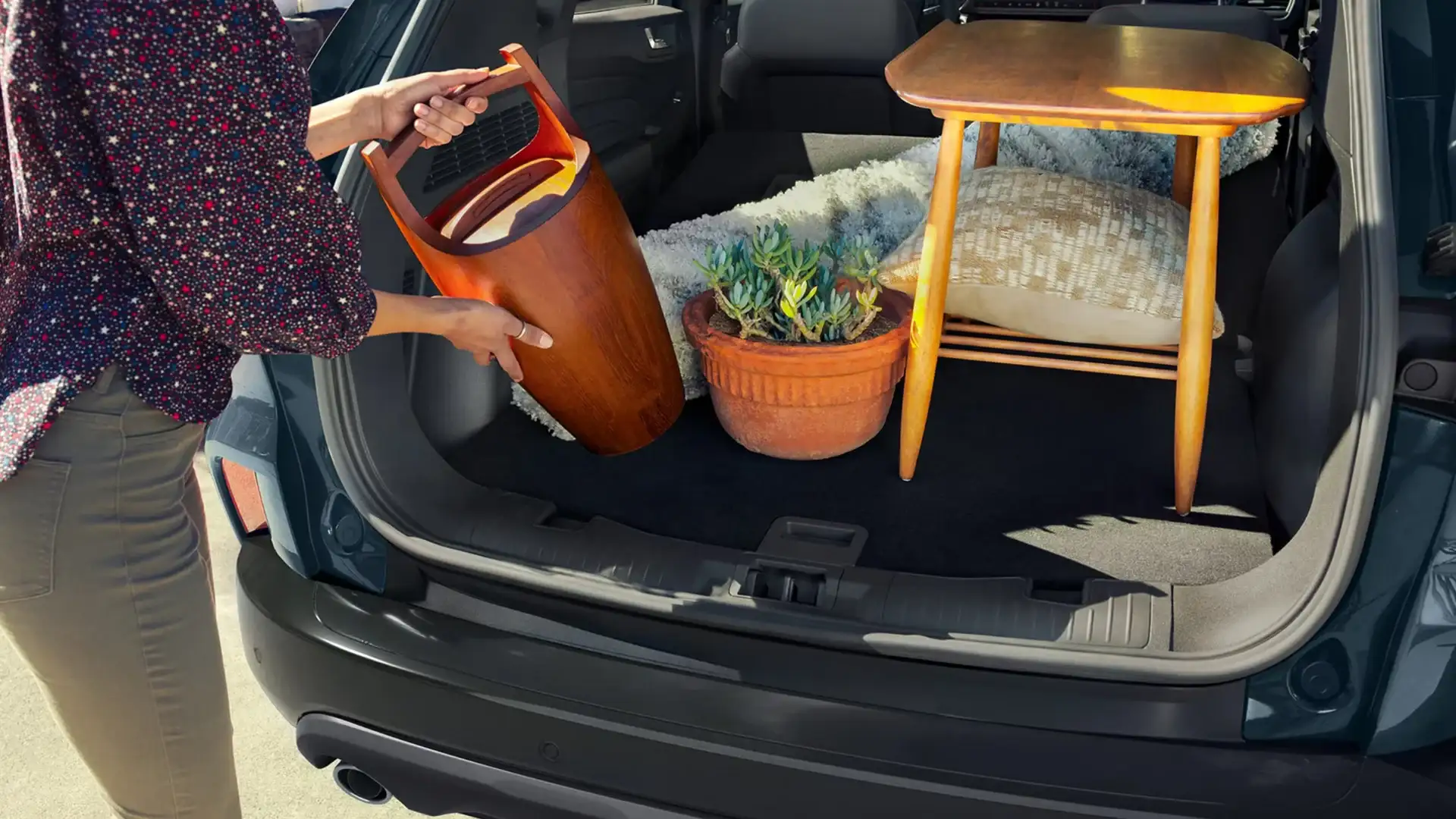 2025 Ford Escape® rear cargo space with table, potted plant, and other items loaded for transport.