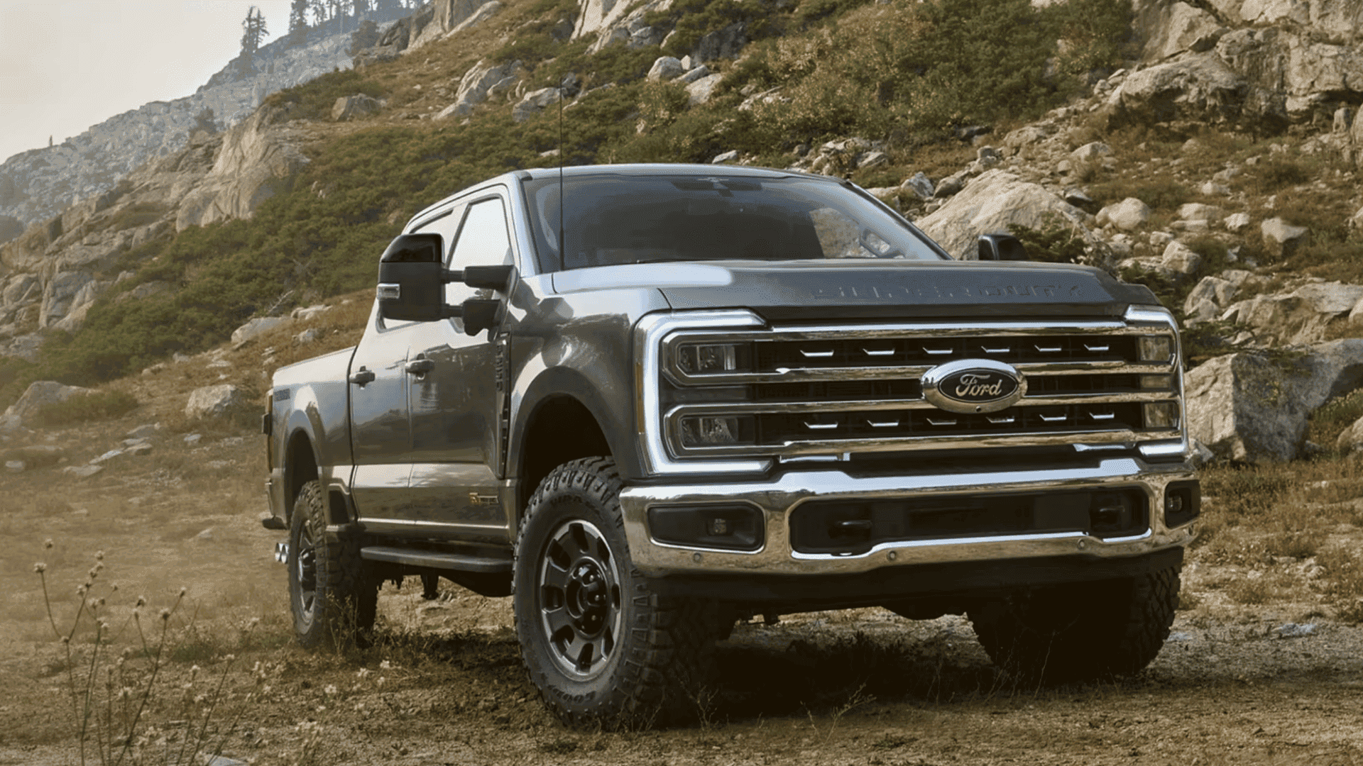 Front three-quarter view of a gray 2026 Ford Super Duty® truck on a rocky mountain terrain.