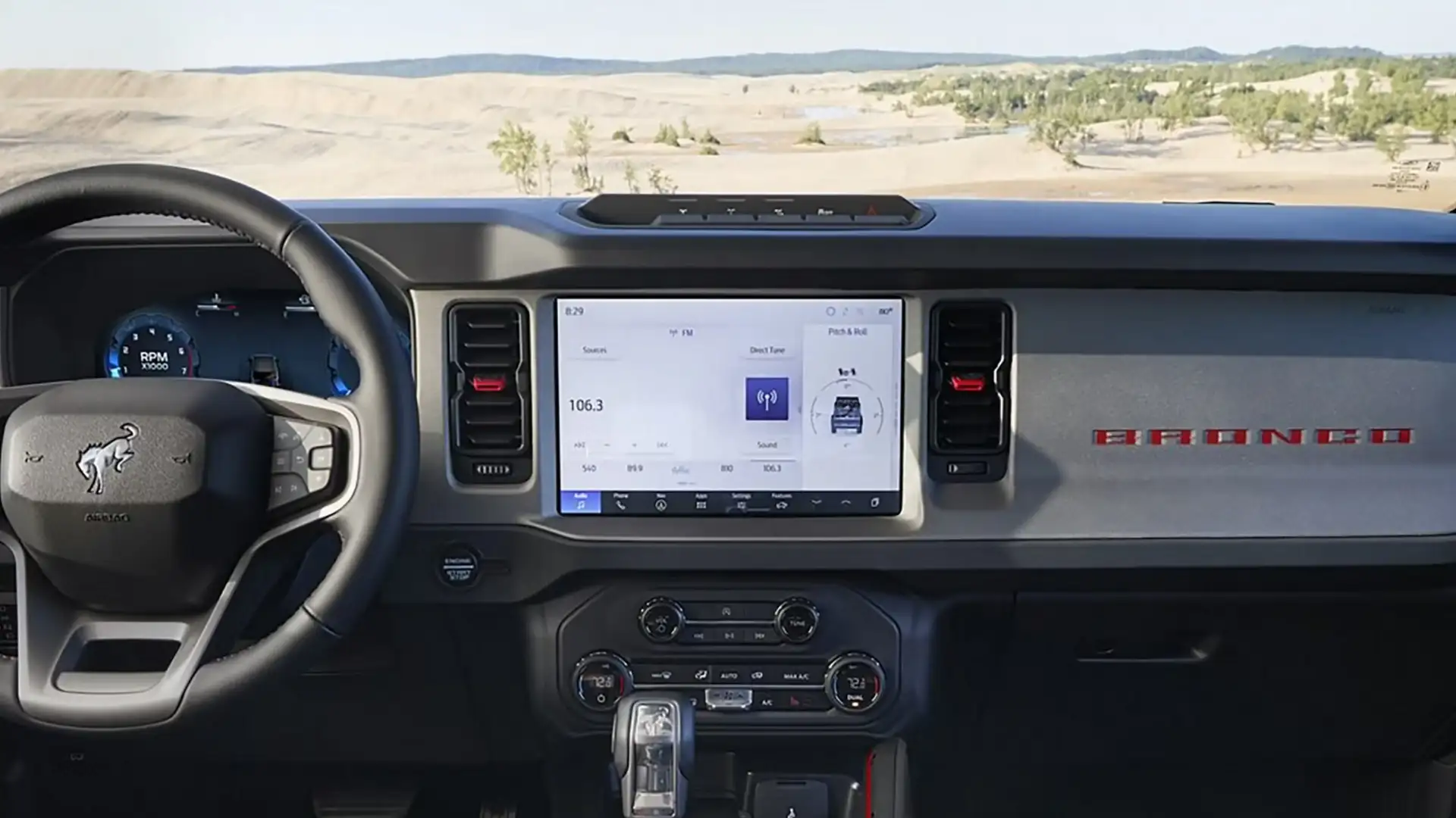 Dashboard of 2025 Ford Bronco® featuring SYNC® touchscreen display, digital gauges, climate controls, and bold BRONCO badging.