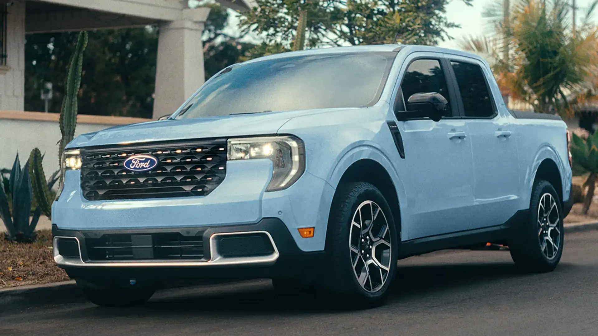 2026 Ford Maverick® light blue compact pickup parked curbside with LED headlights and black alloy wheels.