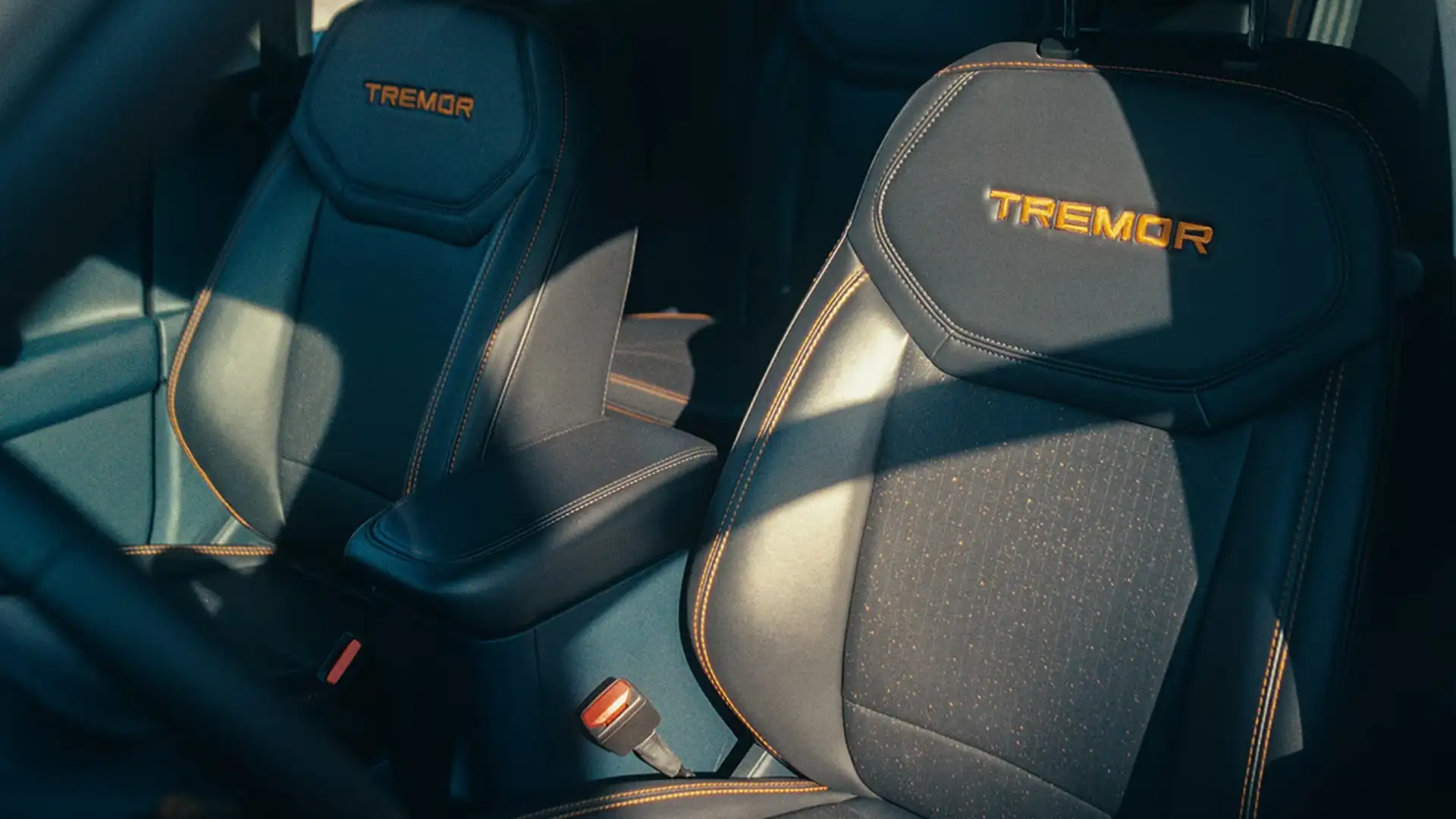 2026 Ford Maverick® Tremor interior with black seats, orange stitching, and Tremor embroidered headrests.