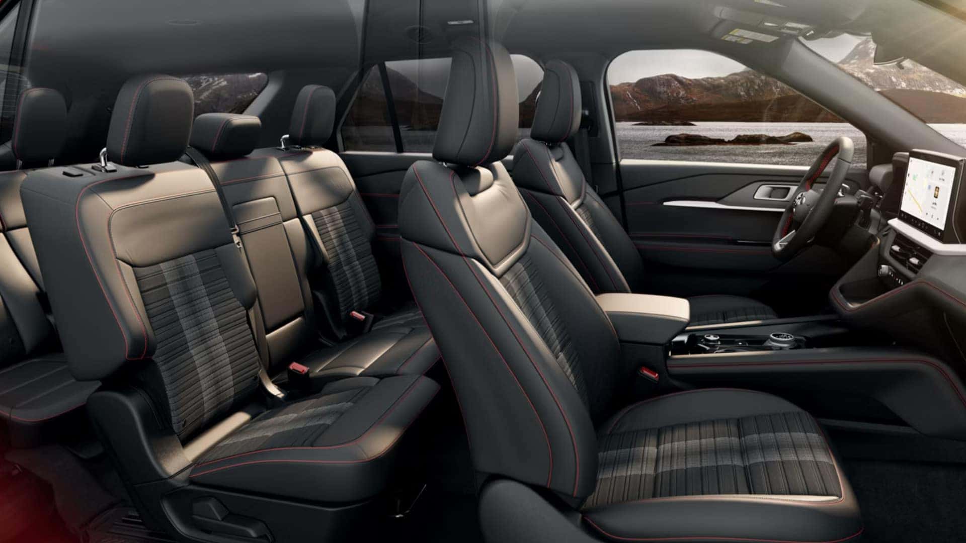 2026 Ford Explorer® interior showing three-row seating with black upholstery, red stitching, and center console controls.
