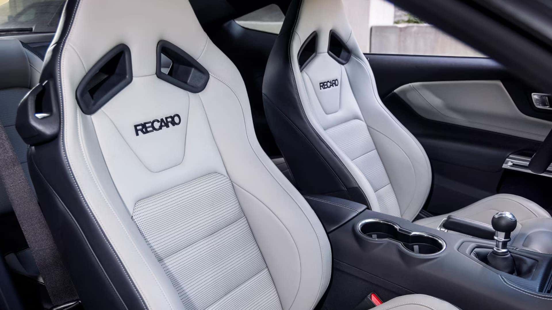 2026 Ford Mustang® interior with white RECARO sport seats, close-up view of the front seats and center console.