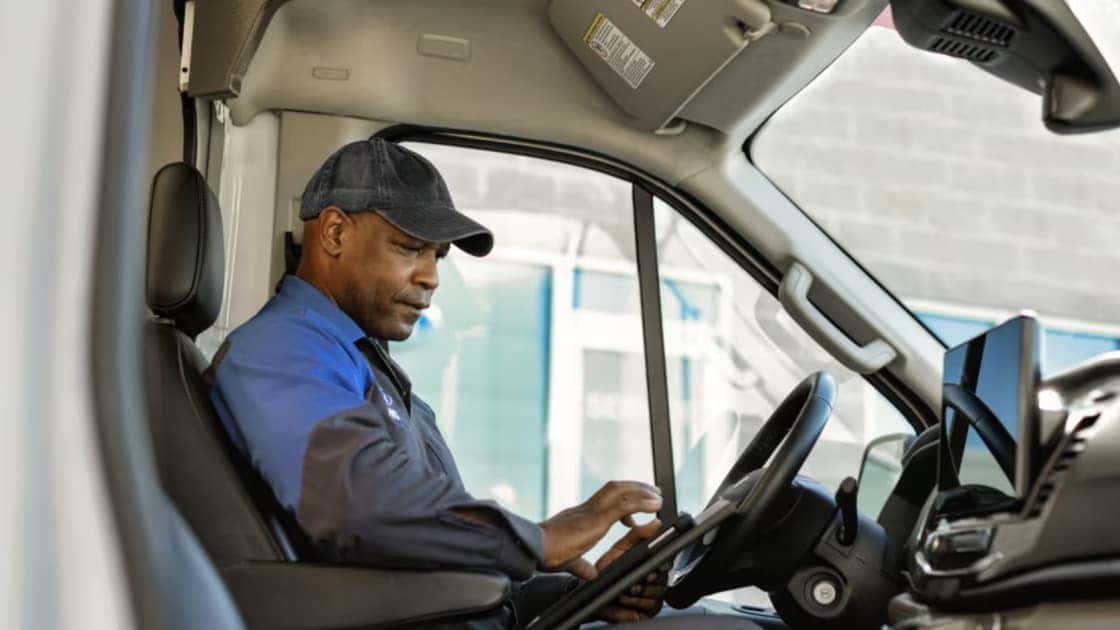 2026 Ford E-Transit™ driver using a tablet inside the van cabin.