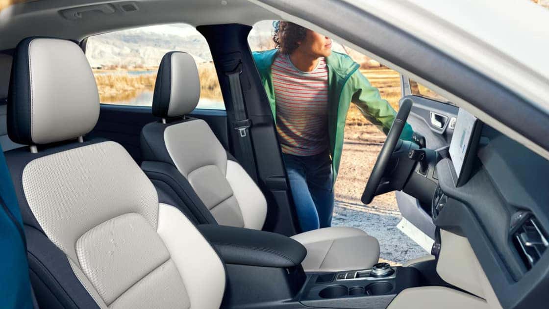 2026 Ford Escape® front seats with light upholstery, center console, and open driver door view.