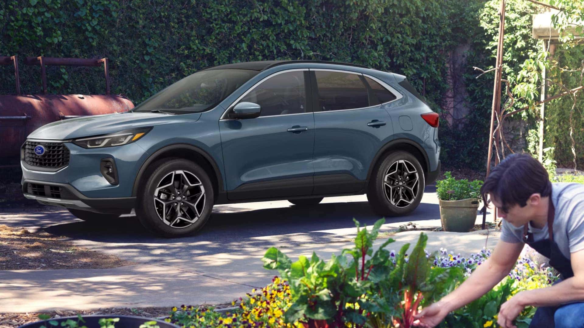 2026 Ford Escape® in blue parked near a home garden with side profile, black wheels, and compact SUV styling.
