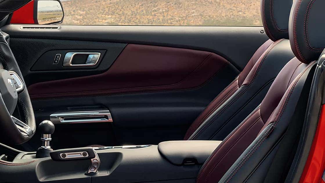 2026 Ford Mustang® interior with sport seats, red stitching, manual shifter, and premium trim details.
