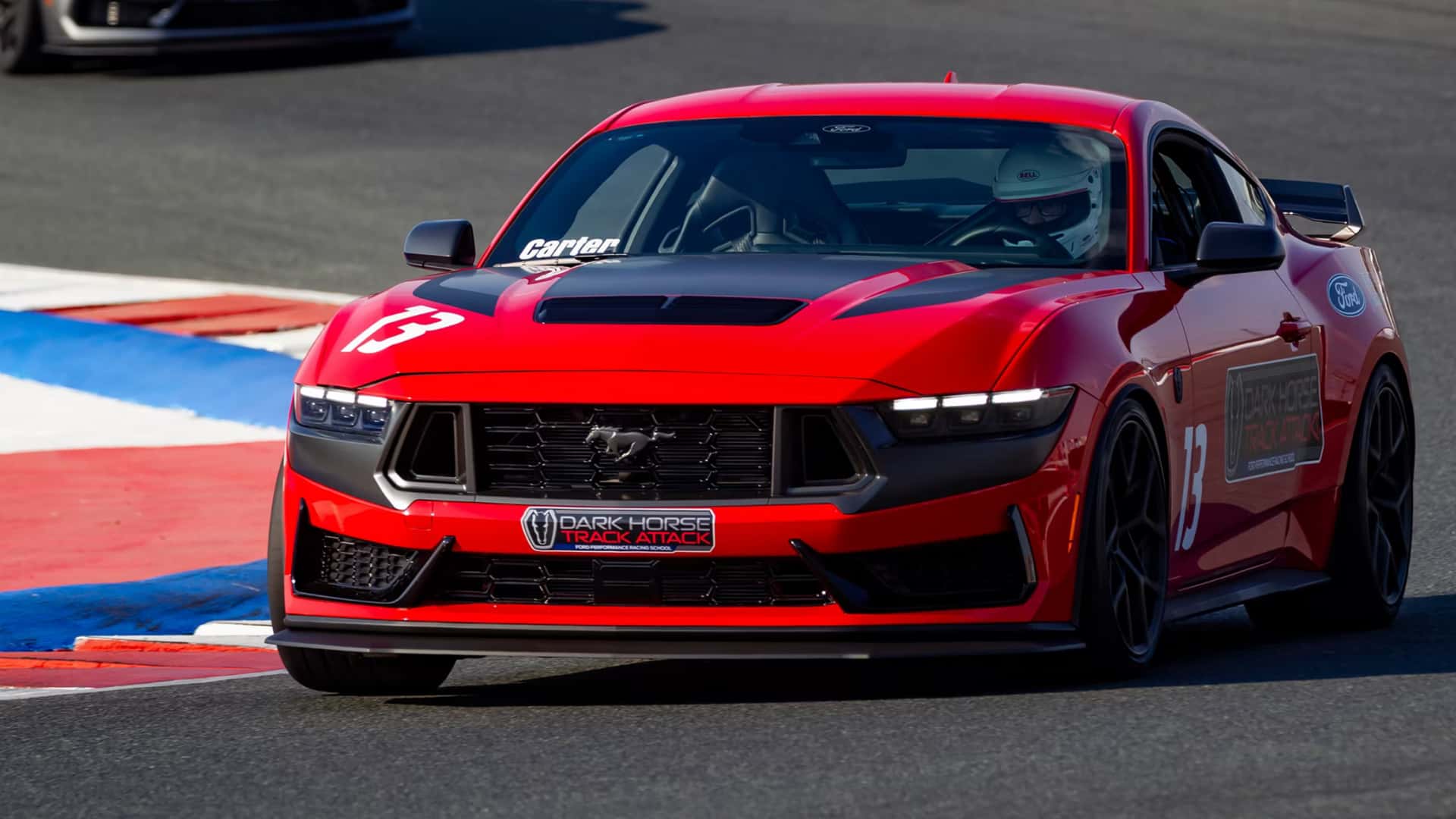 2026 Ford Mustang® Dark Horse Track Attack in red cornering on a race track with black hood accents.