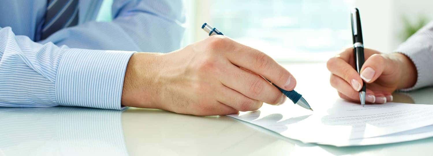 two people signing paperwork