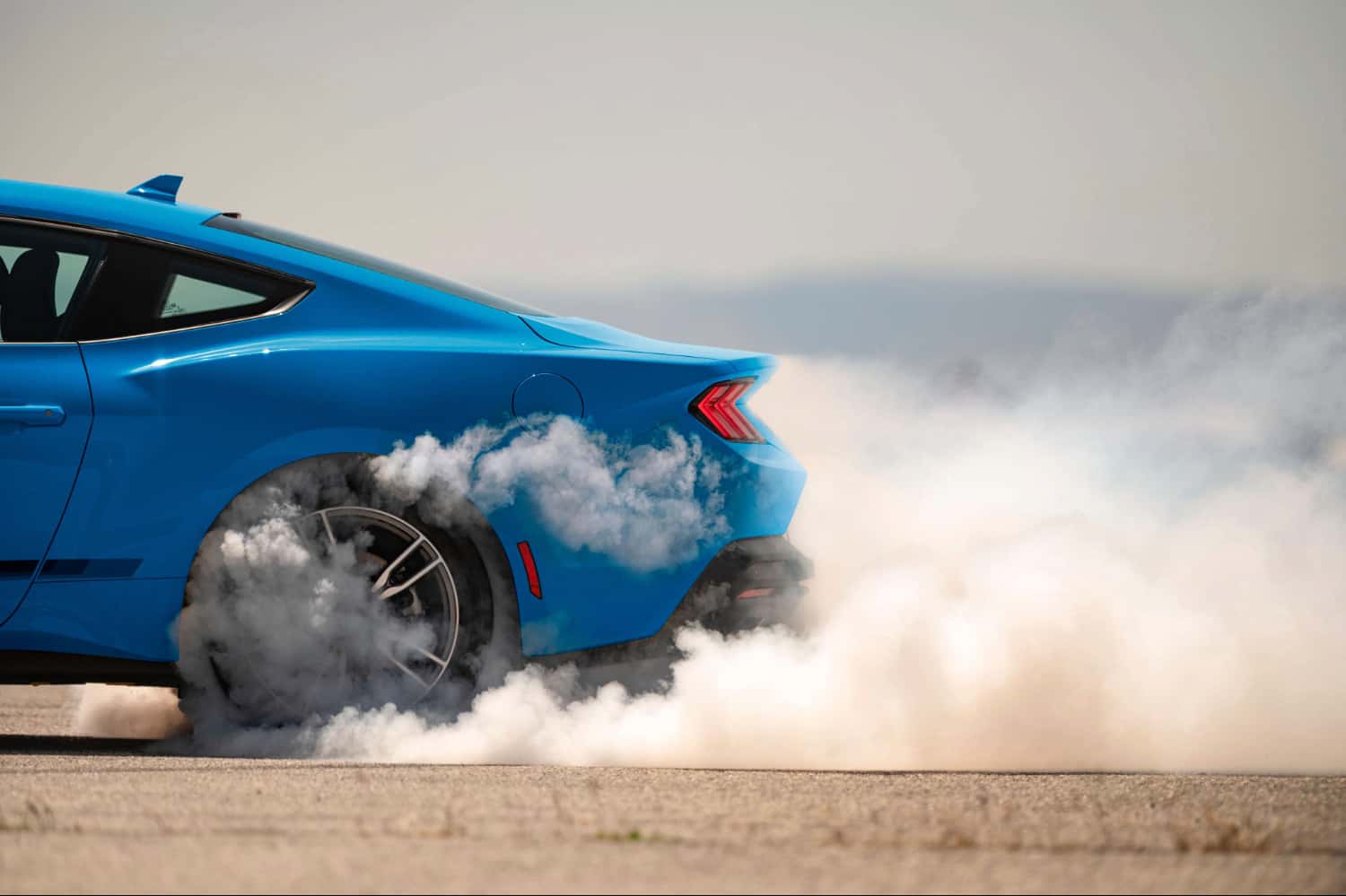 2026 Ford Mustang GT in Grabber Blue doing a burnout