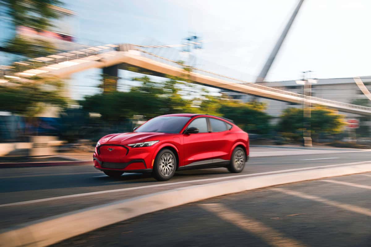 Ford Mustang Mach-E Premium in Rapid Red driving through the city