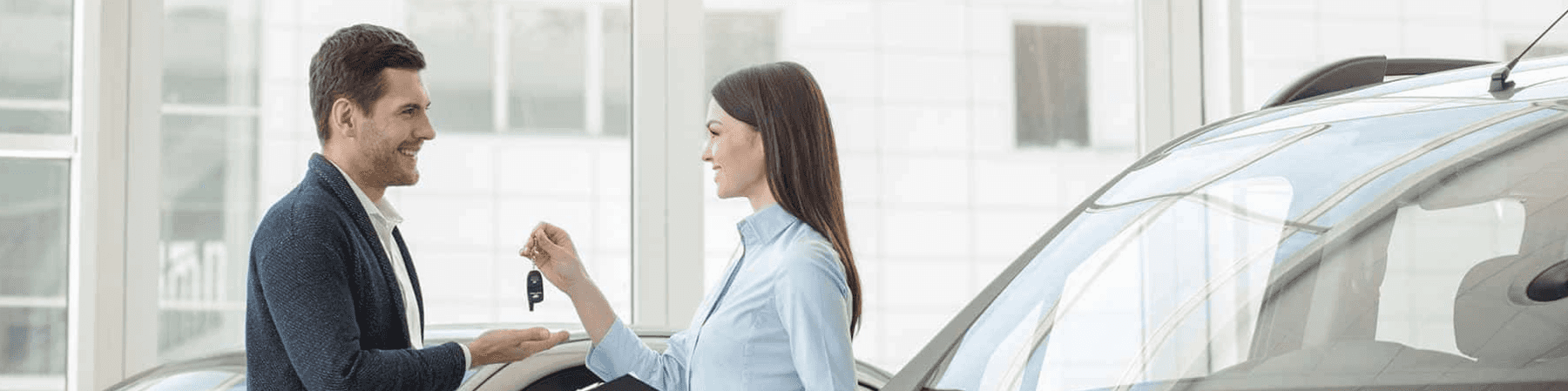 saleswoman handing keys to man