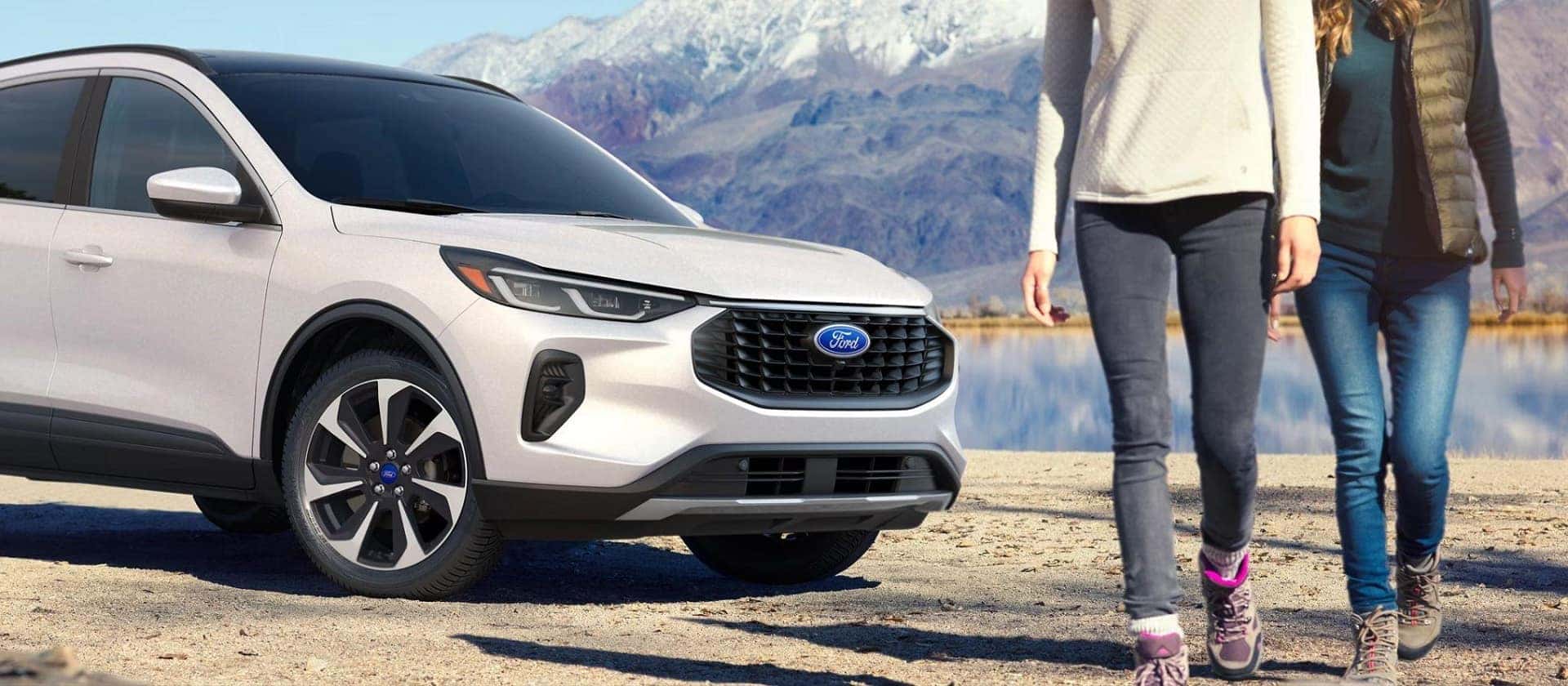 A couple taking a scenic walk in front of their 2025 Ford Escape. A couple taking a scenic walk in front of their 2025 Ford Escape.