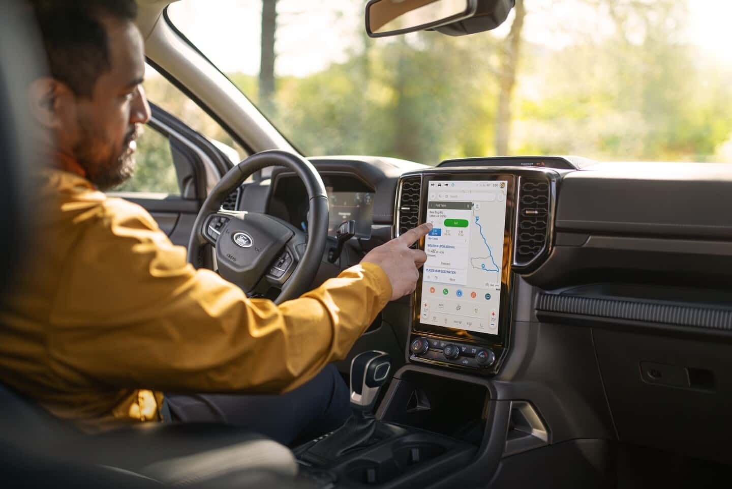 A driver operates the large touchscreen of the 2025 Ford Ranger from the drivers seat. A driver operates the large touchscreen of the 2025 Ford Ranger from the drivers seat.