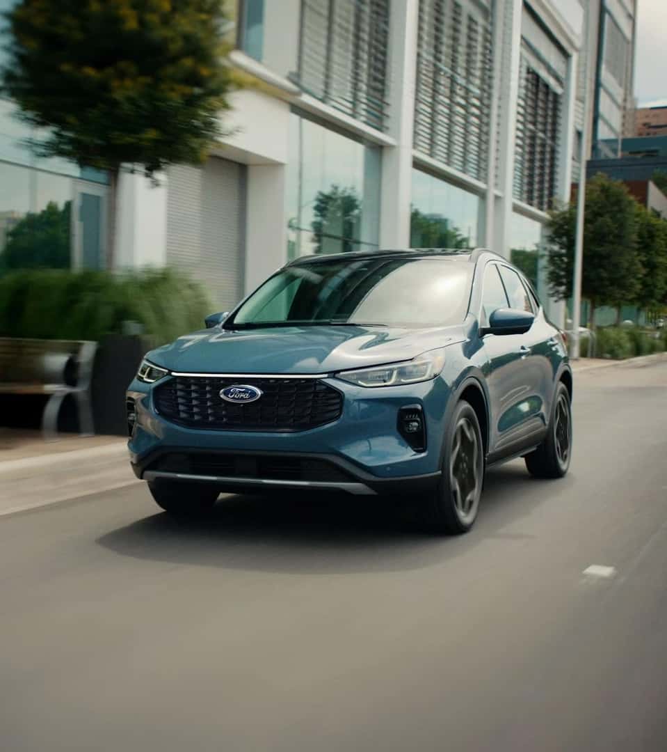 A 2026 Ford Escape driving down a city street.