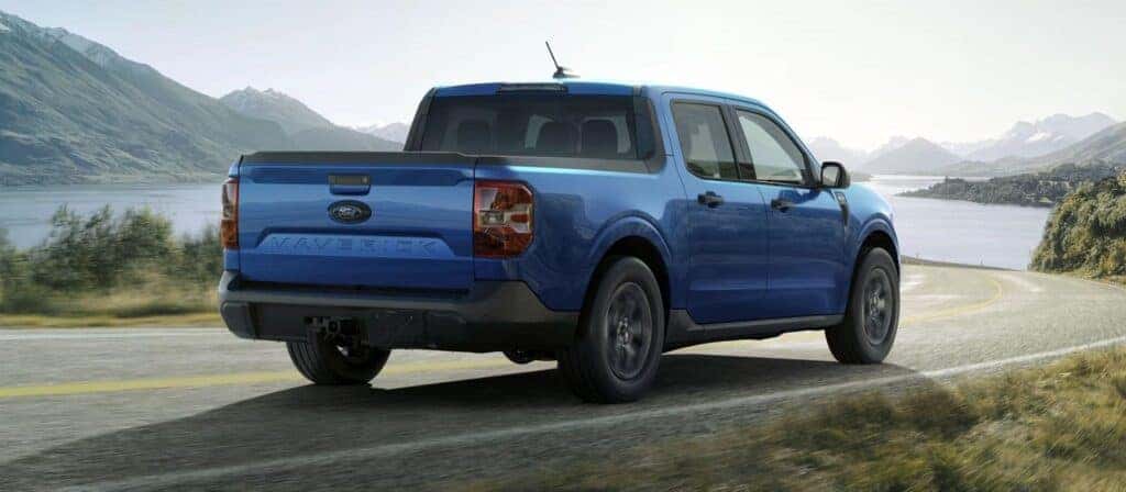 A blue 2025 Ford Maverick driving on a scenic route. A blue 2025 Ford Maverick driving on a scenic route.