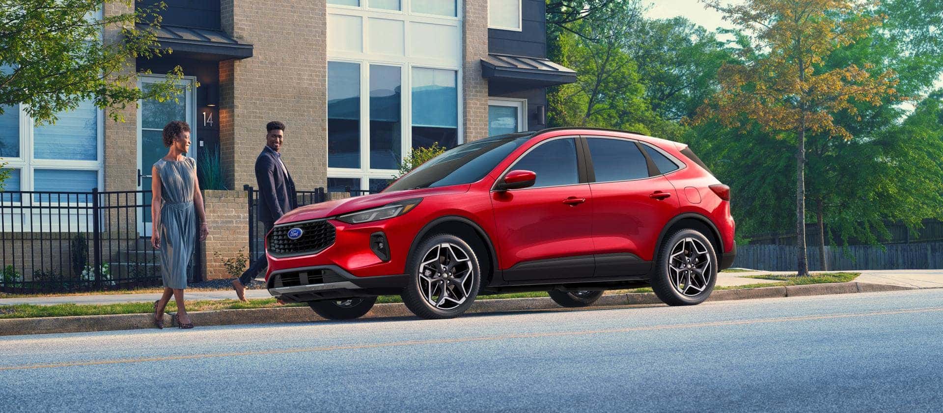 Two people walking up to a 2026 Ford Escape® SUV parked on a city street