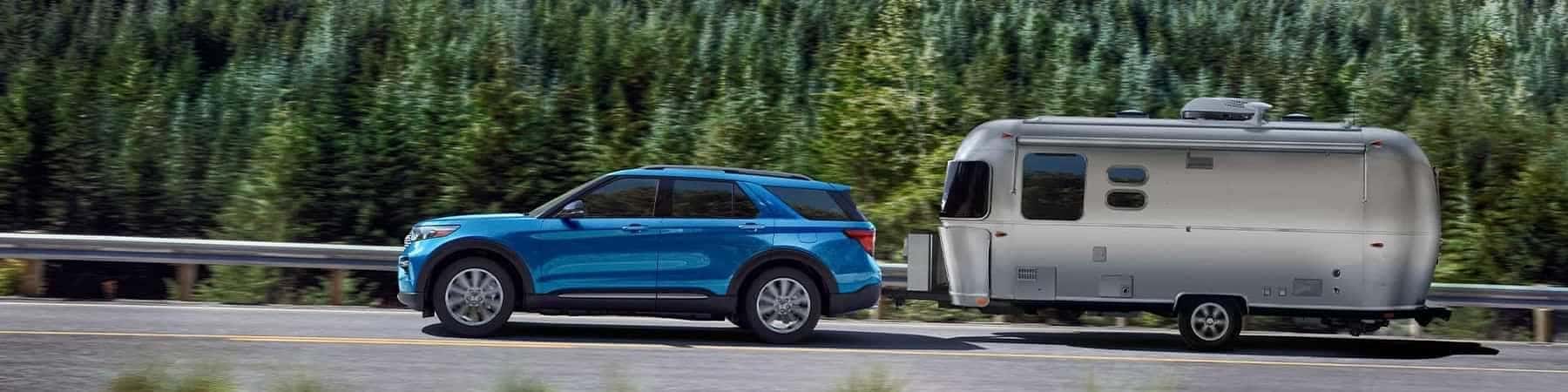 Blue Hybrid 2022 Ford Explorer pulling a camper