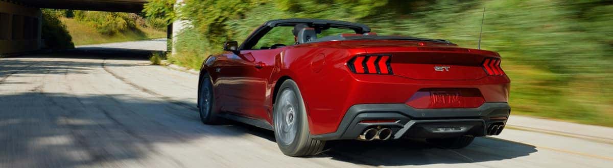 Red Ford Mustang Convertible Driving Down the Road