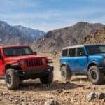 Jeep Wrangler vs Ford Bronco off-road comparison on rugged mountain trail