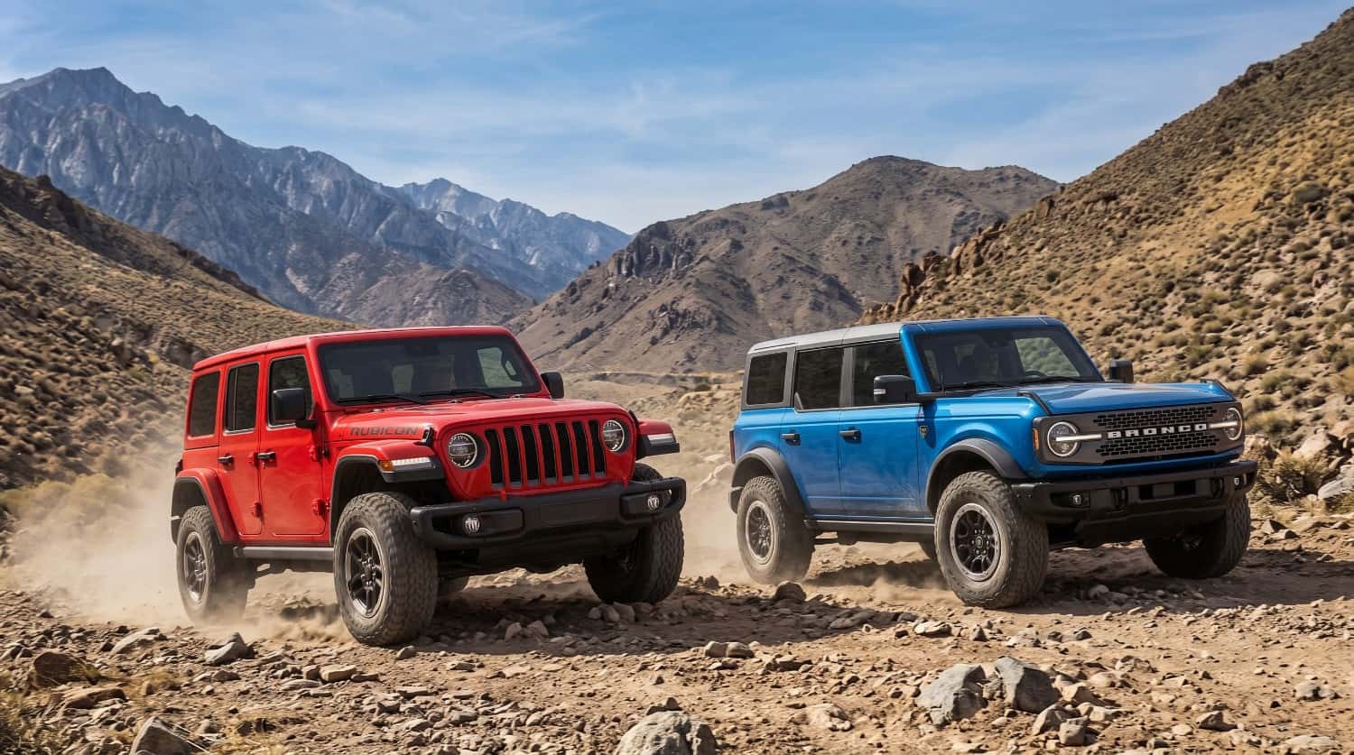 Jeep Wrangler vs Ford Bronco off-road comparison on rugged mountain trail