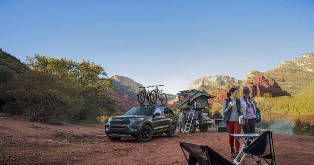 2024 Ford Explorer exterior view in a camping setting with trailer and accessories